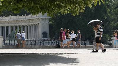 Varias personas disfrutan este lunes en el Parque de El Retiro de Madrid (España), donde las temperaturas ascenderán a más de 44 grados Celsius.