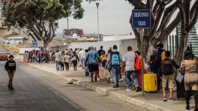Migrantes hacen largas filas para solicitar asilo en Estados Unidos, hoy en el puerto fronterizo del Chaparral en Baja California (México).