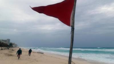 Una bandera roja en la playa indica oleaje agitado y fuertes corrientes debido a la proximidad del huracán 'Beryl' en Cancún (México).