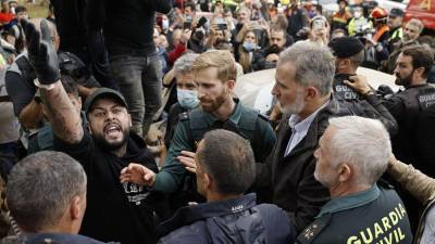 El rey Felipe (d) trata de mediar entre los vecinos indignados, durante su visita a Paiporta este domingo.