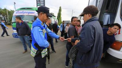 Fotografía de archivo de militares y policías hondureños que piden documentación a migrantes en Honduras.