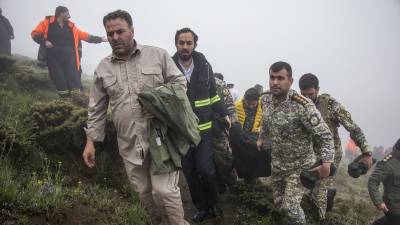 Los miembros del equipo de rescate recuperan el cuerpo de una víctima del lugar del accidente de un helicóptero que transportaba al presidente iraní Ebrahim Raisi en Varzaghan, en el noroeste de Irán, el 20 de mayo de 2024.