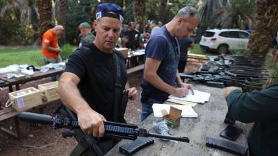 Los civiles israelíes reciben armas tras la ofensiva de Hamás que dejó cientos de muertos.