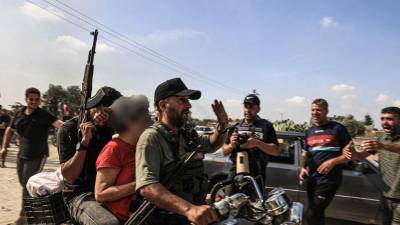 Militantes palestinos transportan en motocicleta a una mujer israelí supuestamente capturada, en Khan Yunis, en el sur de la Franja de Gaza.