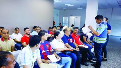 Un agente de Tránsito revisa los documentos a los conductores.