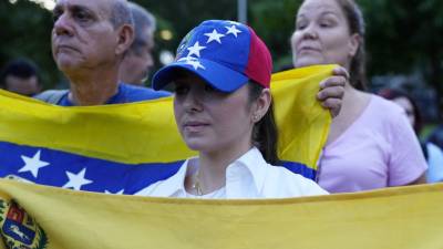 Una mujer venezolana sostiene su bandera nacional durante una manifestación de protesta por el presunto fraude electoral en las controvertidas elecciones presidenciales de Venezuela.