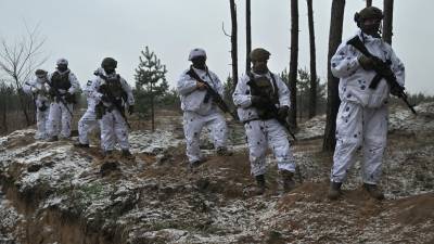 Militares ucranianos en camuflaje de nieve realizan maniobras en el este del país.