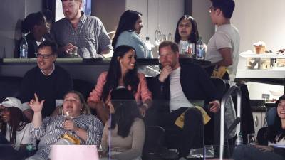 El príncipe Harry junto a su esposa, Meghan Markle, durante un evento deportivo en Los Ángeles.