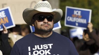 Fotografía de archivo de un hombre con una camiseta en la que se lee Solo parezco ilegal, durante una manifestación.