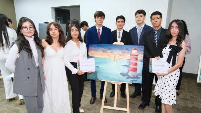 Un grupo de alumnos de onceavo grado posando con su ilustración de “Poema 16”.