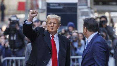 El presidente electo estadounidense, Donald Trump, levanta su puño después de una conferencia de prensa sobre su caso en un tribunal penal en Nueva York.