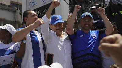 El presidente del Partido Nacional, David Chávez; el jefe de la bancada del Partido Nacional, Tomás Zambrano (i), y el ex jefe del Estado Mayor Romeo Vásquez, participan en una marcha por la defensa del país.