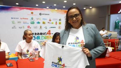 Una sampedrana muestra la camiseta oficinal de Running for The Children.