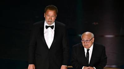US actor Danny DeVito (R) and Austrian-US actor and former Governor of California Arnold Schwarzenegger present the award for Best Visual Effects onstage during the 96th Annual Academy Awards at the Dolby Theatre in Hollywood, California on March 10, 2024. (Photo by Patrick T. Fallon / AFP)