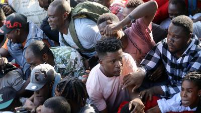 Migrantes sufren una estampida al intentar romper un cerco de seguridad, durante una manifestación frente a las instalaciones de la Comisión Mexicana de Ayuda a Refugiados (Comar) en Tapachula.