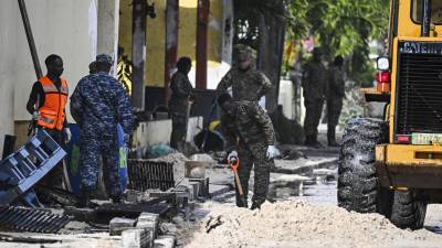 Militares limpian las calles tras las fuertes marejadas provocadas por el huracán Beryl en Barbados.