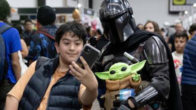 Un asistente al evento se toma foto con una persona disfrazada de Mandalorian durante la ‘Comic-Con’ en Ciudad de Guatemala.