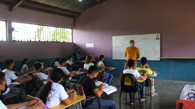 Un docente imparte una clase a sus alumnos en una escuela pública.