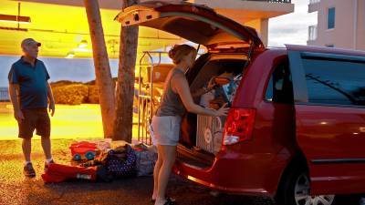 Una familia se prepara para evacuar su residencia en Florida ante la llegada del huracán Idalia.