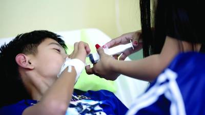 <b>Madre le suministra sales de hidratación oral a su hijo hospitalizado por dengue en un hospital de San Pedro Sula. Foto: Yoseph Amaya</b>