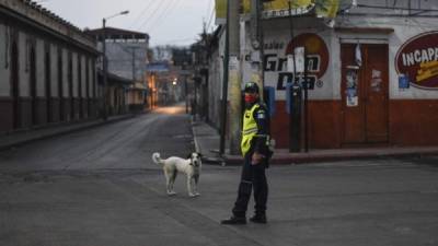Un policía con mascarilla recorre las desoladas calles de la localidad de Amatitlán.
