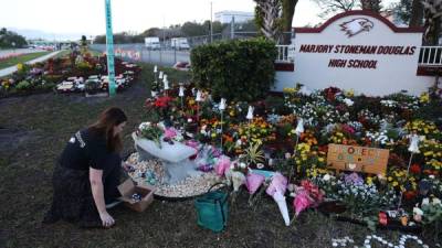 Una persona visita la instalación conmemorativa en Marjory Stoneman Douglas High School para las personas que murieron durante un tiroteo masivo el 14 de febrero en Parkland. AFP