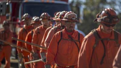 En la cárcel son presos, pero afuera son bomberos, como cualquier otro. / AFP FOTO/ DAVID MCNEW