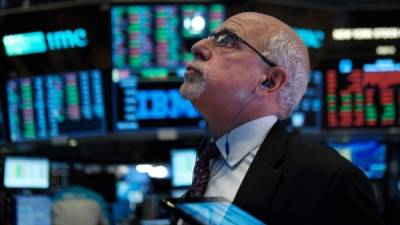 Un corredor de la Bolsa de Nueva York, observa los resultados de las cotizaciones en las pantallas del parqué.