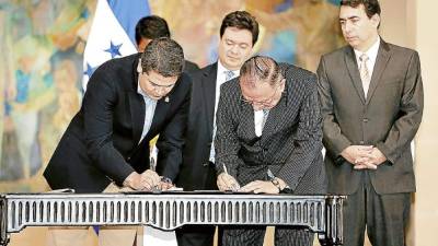 El presidente Juan Orlando Hernández firmó ayer el convenio sobre vivienda con ejecutivos de Banco Atlántida.