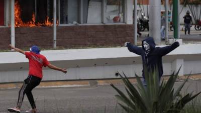 Simpatizantes del Partido Libertad y Refundación queman una farmacia cuando se enfrentan a la policía durante una nueva jornada de protesta en contra del presidente de Honduras, Juan Orlando Hernández, en Tegucigalpa (Honduras). EFE