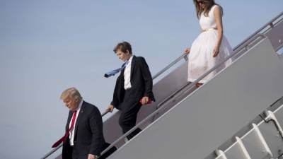 US President Donald Trump, his son Barron and First Lady Melania Trump step off Air Force One at Andrews Air Force Base, Maryland, April 16, 2017. / AFP PHOTO / JIM WATSON
