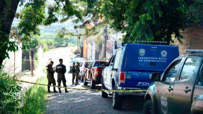 Policías y elementos del Ministerio Público toman nota del hallazgo de uno de los cuerpos.