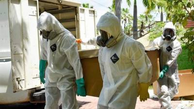 Trabajadores del cementerio Parques de la Paz cargan una caja de cartón con un fallecido presuntamente por COVID-19 en el sector de la Aurora de Daule, provincia de Guayas (Ecuador). EFE/Mauricio Torres/Archivo