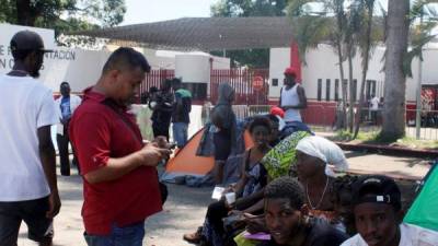 Migrantes de origen africano esperan hoy jueves, a las afueras de la Garita Siglo XXI en espera de atención para resolver su situación migratoria en la ciudad de Tapachula, estado de Chiapas.
