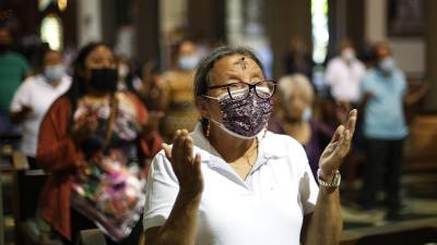 Una mujer católica participando de las actividades litúrgicas.