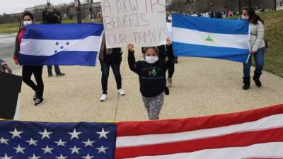 Decenas de hondureños sostienen pancartas y banderas estadounidenses mientras marchan dirección a la Casa Blanca, en Washington (EEUU). EFE/ Lenin Nolly/Archivo