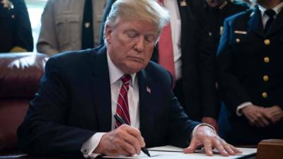 Trump se declaró 'orgulloso' del veto, que exhibió tras firmarlo. AFP.