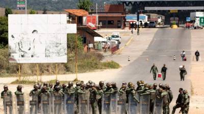 Miembros de la Guardia Nacional Bolivariana (GNB, policía militarizada) de Venezuela montan guardia este domingo en el paso fronterizo entre Brasil y Venezuela ubicado en la localidad de Pacaraima. EFE