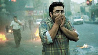 Iranian protesters cover their face from tear gas during clashes with riot police in Tehran on June 20, 2009. Thousands of Iranians clashed with police as they defied an ultimatum from supreme leader Ayatollah Ali Khamenei for an end to protests over last week's disputed presidential election. TOPSHOTS/AFP PHOTO/ALI SAFARI