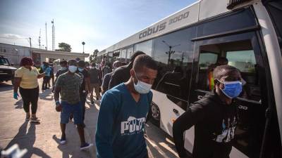 Migrantes haitianos mientras descienden de un autobús luego de su llegada al país tras ser deportados desde Estados Unidos.
