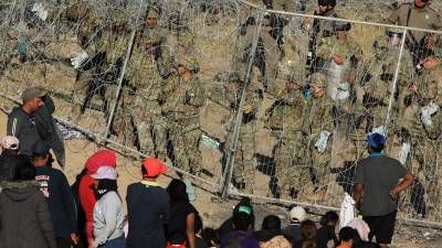 Personal de la Guardia Nacional estadounidense refuerzan una cerca de navajas y púas en la entrada de migrantes que permanecen en las inmediaciones de la frontera con México, en Ciudad Juárez.