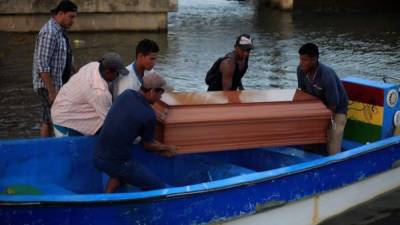 Un grupo de hombres carga el féretro de un familiar que murió en un bote que se volcó este jueves, en la Base Naval de Cataratas, Puerto Lempira, en el departamento Gracias a Dios, Honduras. EFE/ Jorge Cabrera
