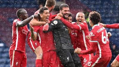 Alisson Becker celebró su gol con sus compañeros del Liverpool. Foto AFP.