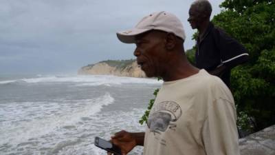 Dos hombres observan el oleaje en la playa de While Horses hoy en Jamaica. EFE