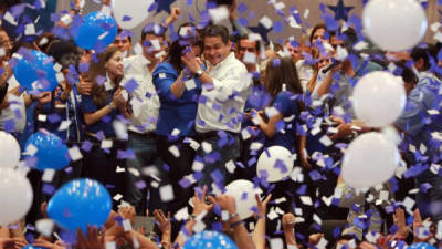 El candidato presidencial del gobernante Partido Nacional, Juan Orlando Hernández (c-d) baila con su esposa Ana de Hernández (c-i) para celebrar hoy, domingo 24 de noviembre de 2013.