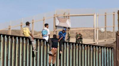 Cientos de migrantes centroamericanos alcanzaron hoy la frontera México-Estados Unidos y treparon la valla que divide ambos países desafiando a los agentes de la Patrulla Fronteriza y al presidente estadounidense, Donald Trump.