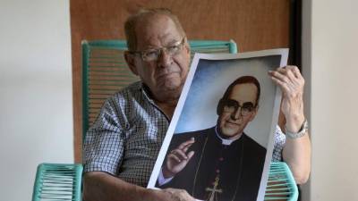 Gaspar Romero sostiene un retrato de su venerado hermano en su domicilio.