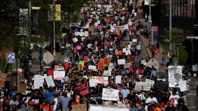Miles de manifestantes se concentraron hoy ante la Alcaldía de Baltimore (Maryland, EE.UU.) en un nuevo día de protestas, en un clima más calmado tras el anuncio ayer de la imputación de seis policías por la muerte del joven negro Freddie Gray, después de estar en custodia policial.