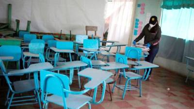 Ana Cristina González, maestra de la escuela 'Salvador Corleto', fue registrada al ordenar unos libros en un salón vacío, durante la suspensión de clases por la pandemia del COVID-19, en la aldea de Zuntule, al oriente de Tegucigalpa (Honduras). EFE/ Gustavo Amador