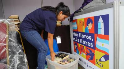 Una mujer organizando libros, en la Segunda Feria Internacional del Libro (FIL), en Tegucigalpa.